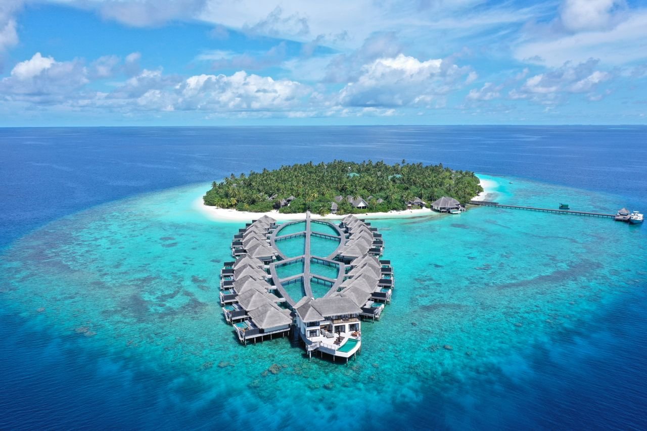 Stunning aerial view of a luxury resort on Gaafu Dhaalu Atoll, Maldives, surrounded by turquoise waters.